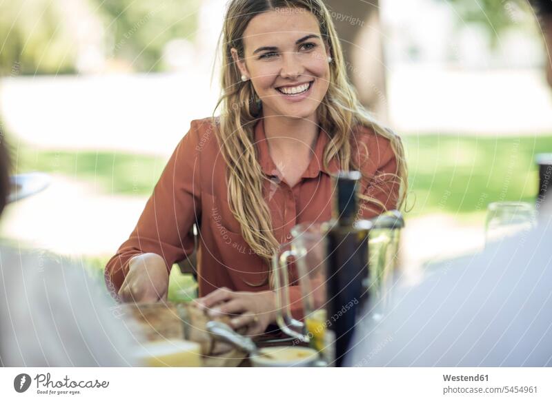 Smiling woman at family lunch in garden group of people Group groups of people smiling smile eating friends celebrating celebrate partying persons human being