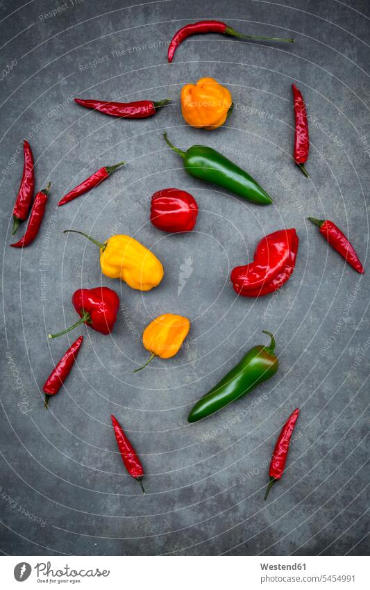 Various chili pods on grey background yellow gleaming various different arrangement grouping sort sorts divers hot spicy Red Chilli Pepper Red Chili Peppers