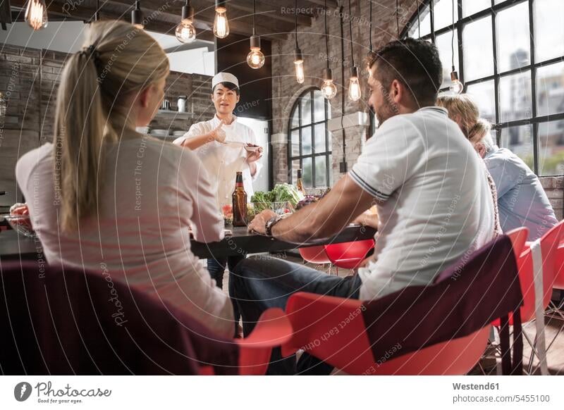 Female chef talking to students in cooking class female cook speaking group of people Group groups of people cooks Chefs persons human being humans human beings