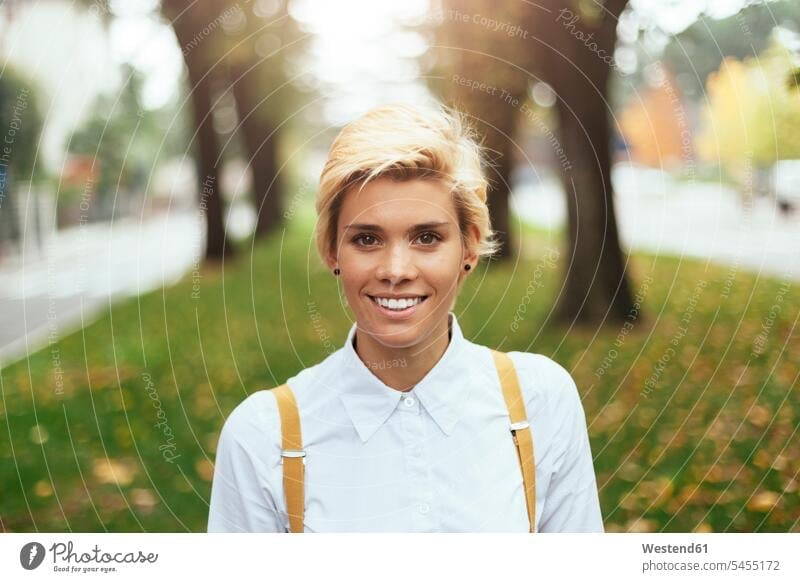 Portrait of a teenage girl in a park, smiling blond blond hair blonde hair Teenage Girls female teenagers smile happiness happy hip trendy portrait portraits