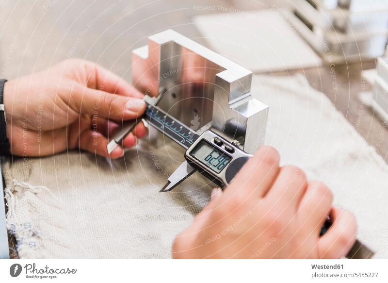 Detail of woman measuring metal workpiece working At Work factory factories females women measure measurement Adults grown-ups grownups adult people persons