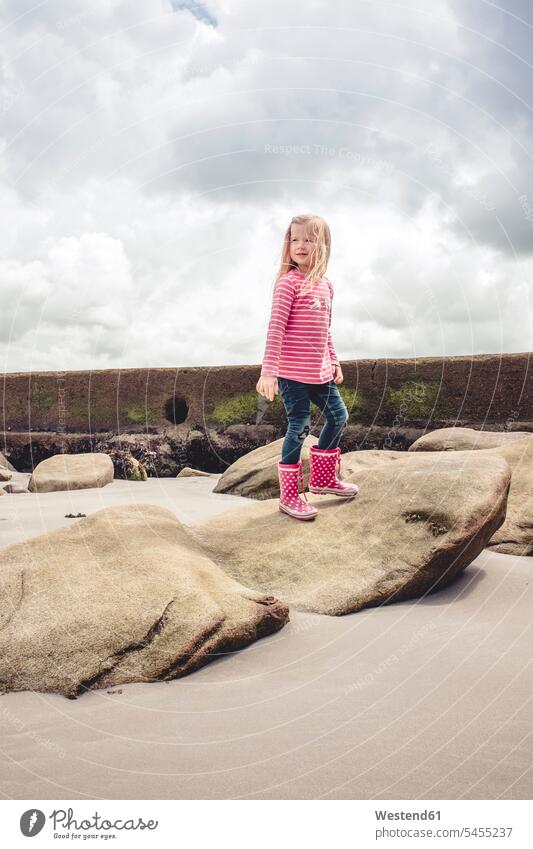 France, Bretagne, Douarnenez, little girl standing on a rock at the beach females girls beaches child children kid kids people persons human being humans