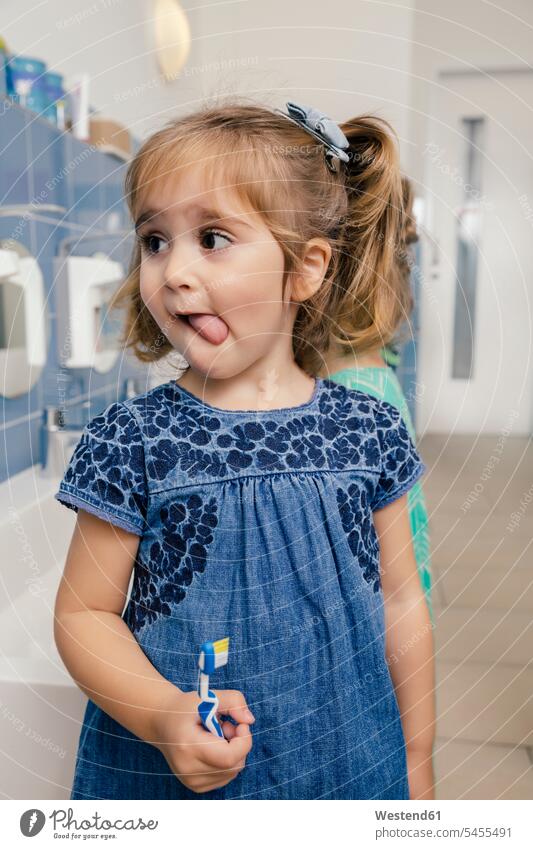 Portrait of girl with toothbrush in bathroom of a kindergarten nursery school tooth-brushes toothbrushes brushing teeth females girls pedagogics child children