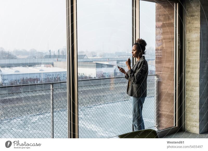 Businesswoman using cell phone at the window talking speaking mobile phone mobiles mobile phones Cellphone cell phones windows females women businesswoman