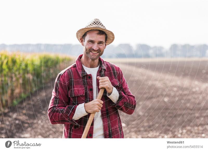 Portrait of confident farmer on field portrait portraits agriculturists farmers Field Fields farmland smiling smile man men males agriculture Adults grown-ups