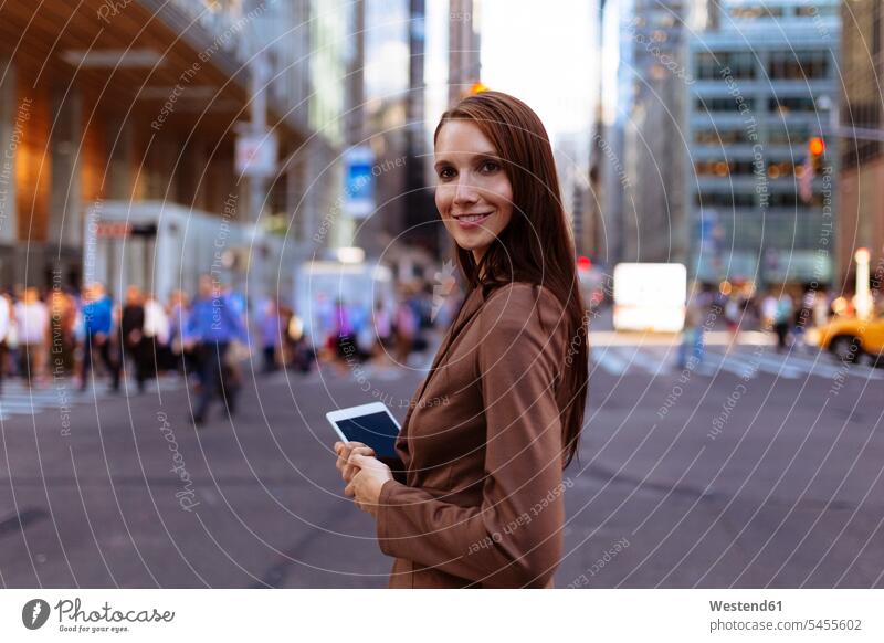 USA, New York, Manhattan, Young woman walking in the street, holding mobile  phone - a Royalty Free Stock Photo from Photocase
