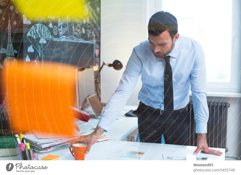 Businessman working at desk in office At Work Business man Businessmen Business men business people businesspeople business world business life offices