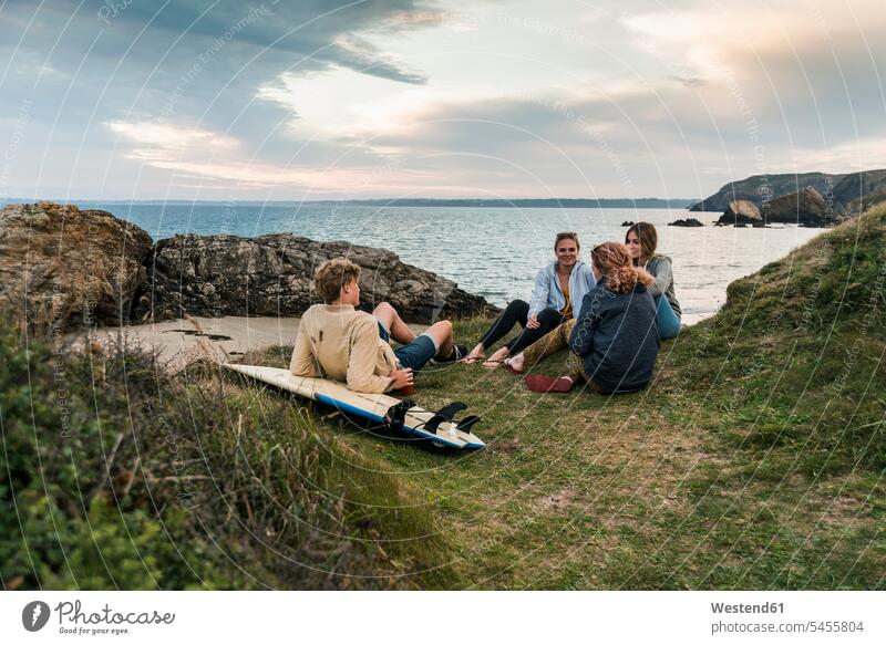 Happy friends with surfboard socializing at the coast at sunset surfboards coastline shoreline happiness happy surfing surf ride surf riding Surfboarding