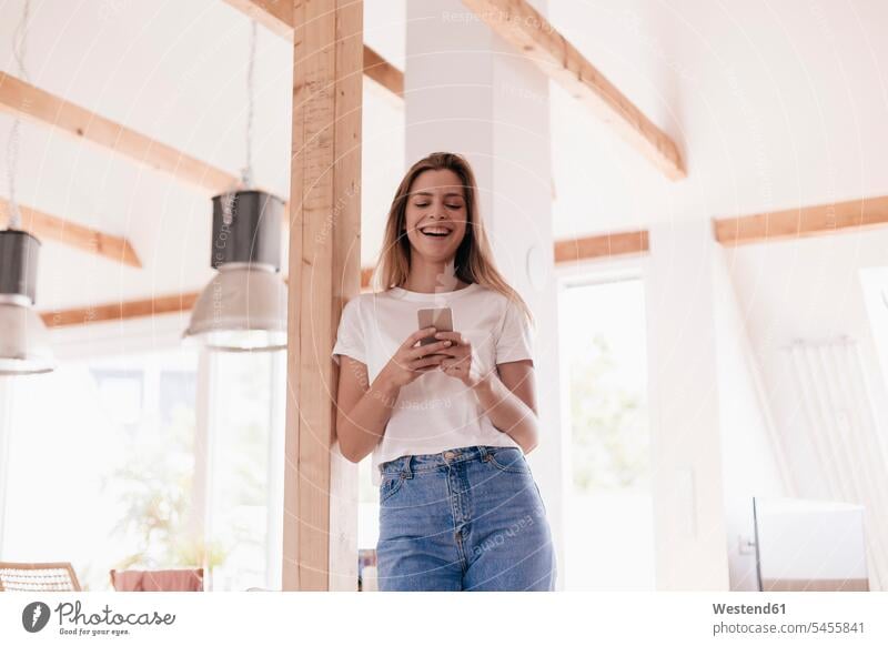 Young woman at home using smartphone mobile phone mobiles mobile phones Cellphone cell phone cell phones females women message cozy sociable comfortable cosy