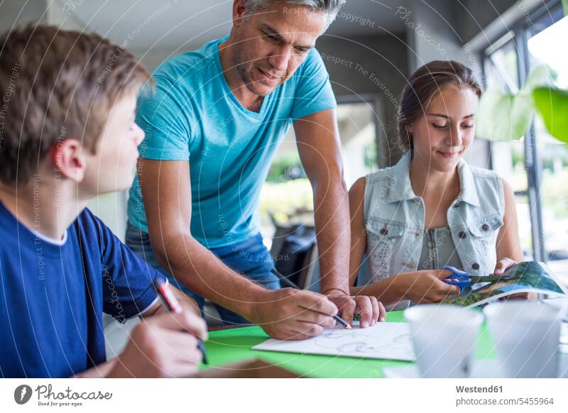 Man, boy and girl working on a project teaching student pupils father pa fathers daddy dads papa learning education schoolchildren parents family families