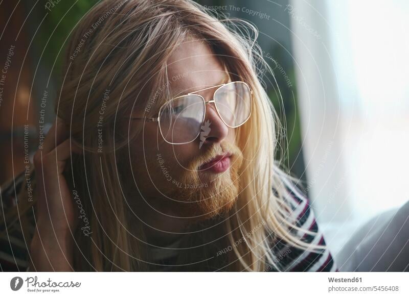 Portrait of man with long blond hair wearing spectacles portrait portraits men males glasses specs Eye Glasses Eyeglasses Adults grown-ups grownups adult people