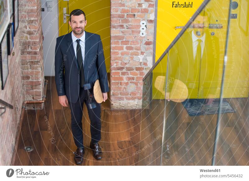 Young businessman in a suit carrying longboard, climbing stairs caucasian caucasian ethnicity caucasian appearance european Mobility mobile Longboard