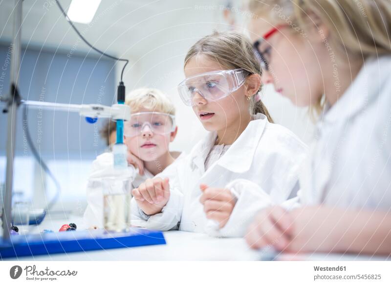 Pupils experimenting in science class watching school schools student pupils looking view seeing viewing schoolchildren education effort attempt checking Test