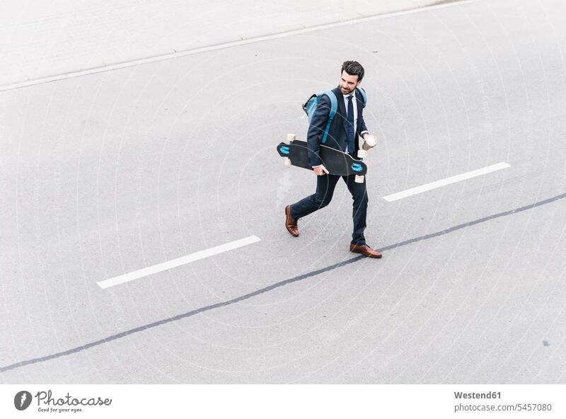 Businessman with takeaway coffee and skateboard walking on the street road streets roads Business man Businessmen Business men Coffee Skate Board skateboards