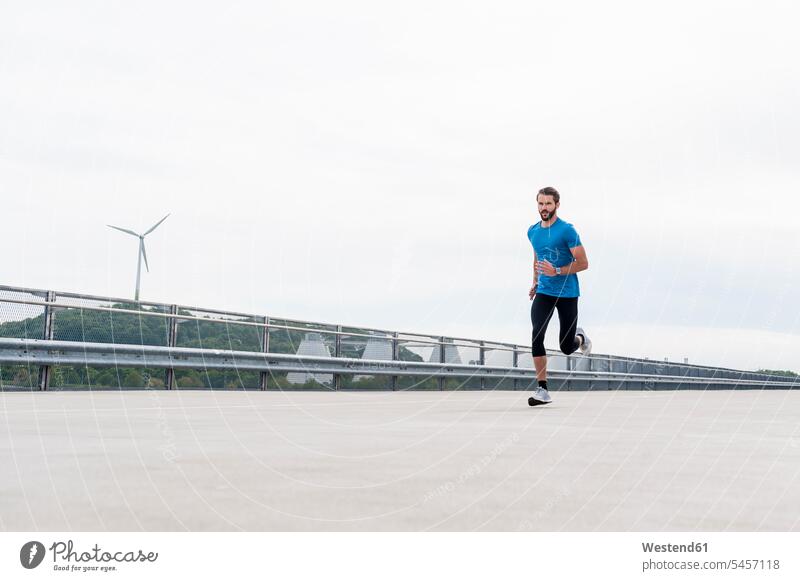 Man running on a parking level man men males Adults grown-ups grownups adult people persons human being humans human beings parking garage parking garages