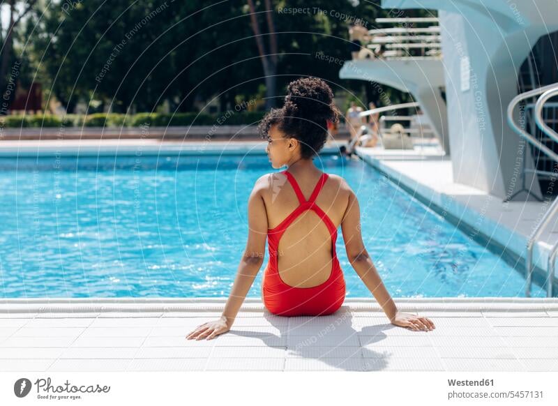 Young woman stretching in swimming pool - a Royalty Free Stock