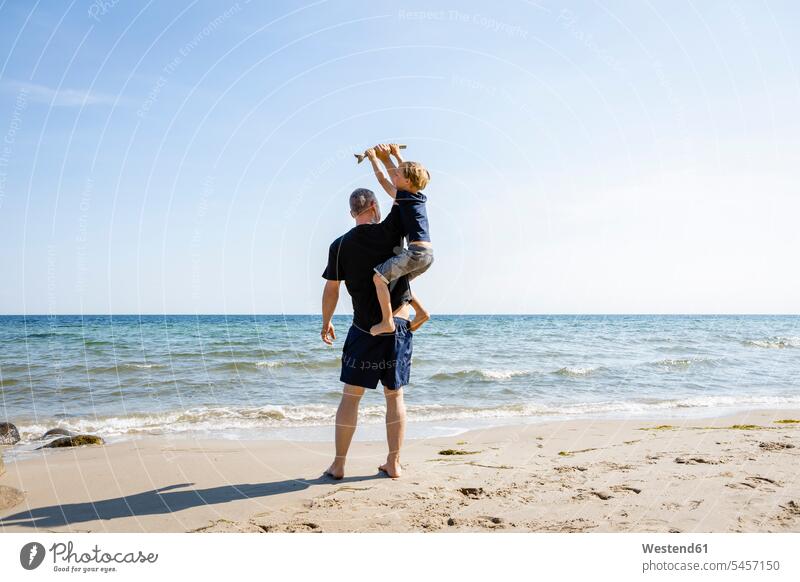 Father and son playing at the beach sons manchild manchildren father pa fathers daddy dads papa beaches family families people persons human being humans