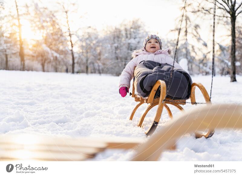 Happy girl on sledge in winter landscape happiness happy winter landscapes females girls scenery terrain child children kid kids people persons human being