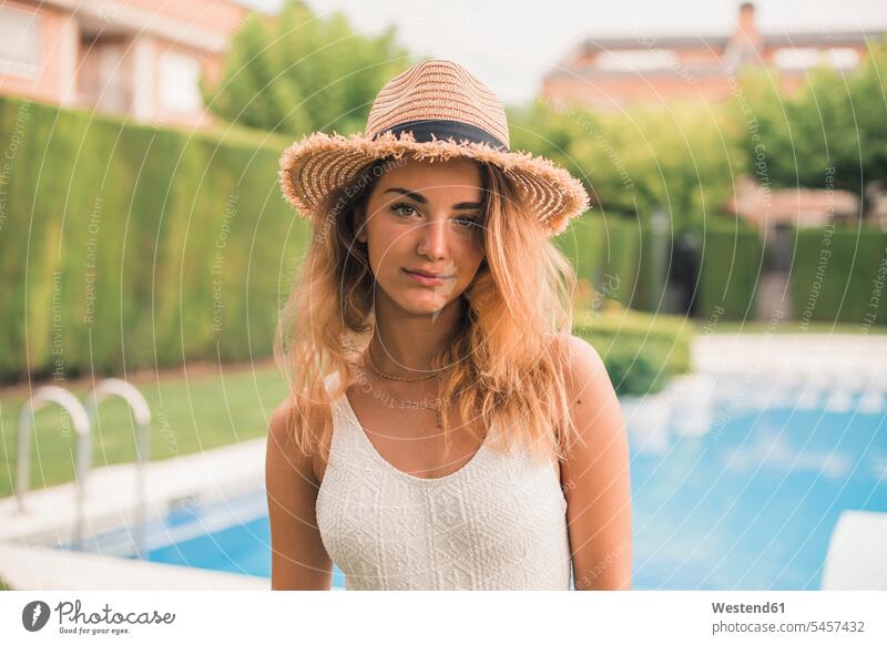 Portrait of young woman with straw hat and swimsuit, pool in the background Swimming Costume bathing costume bathing costumes Swimming Suit bathing suit