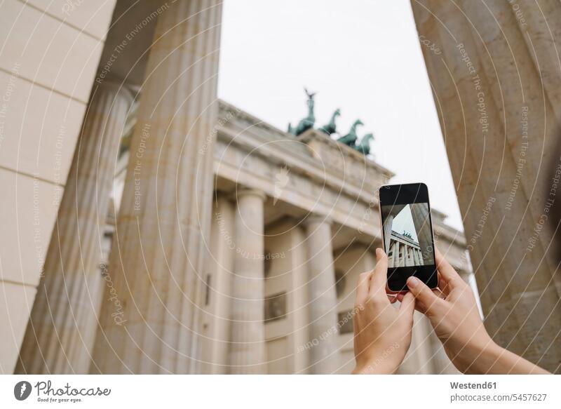 Crop view of hands taking photo of Branderburg gate with smartphone, Berlin, Germany phones telephone telephones cell phone cell phones Cellphone mobile