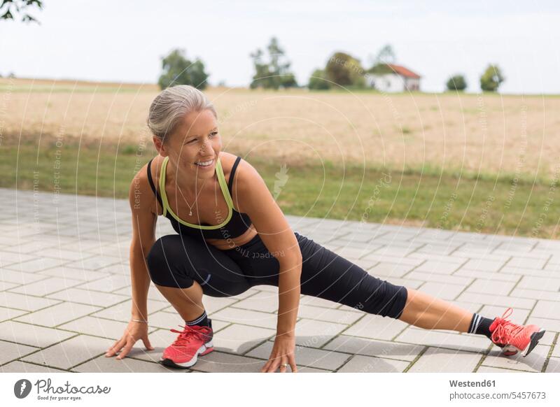 Mature woman doing workout in the countryside in summer rural working out work out females women summer time summery summertime Adults grown-ups grownups adult