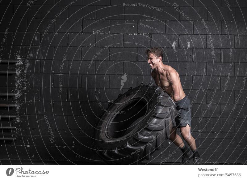 Athlete with an amputated arm exercising with tractor tire human human being human beings humans person persons caucasian appearance caucasian ethnicity