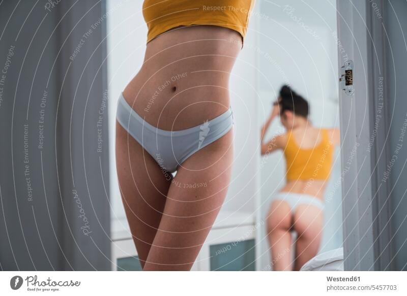 Woman in underwear in front of a mirror - SuperStock