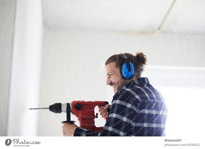 Happy worker using electric drill on a construction site Occupation Work job jobs profession professional occupation blue collar blue collar worker