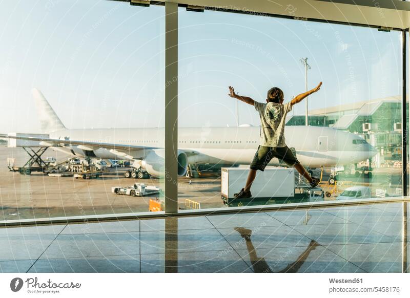 Spain, Barcelona airport, Boy in departure area, jumping in front of glass pane caucasian caucasian ethnicity caucasian appearance european Travel mid-air