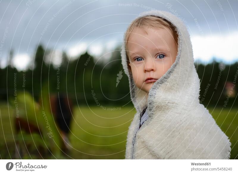 Portrait of serious little girl wearing hooded jacket portrait portraits Hooded Jackets baby girls female earnest Seriousness austere coat coats jackets babies