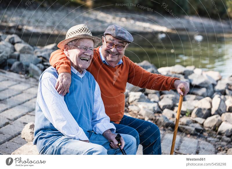 Two old friends sitting by the riverside, having fun Seated riverbank Best Friend Best Friends Best Pal cheerful gaiety Joyous glad Cheerfulness exhilaration