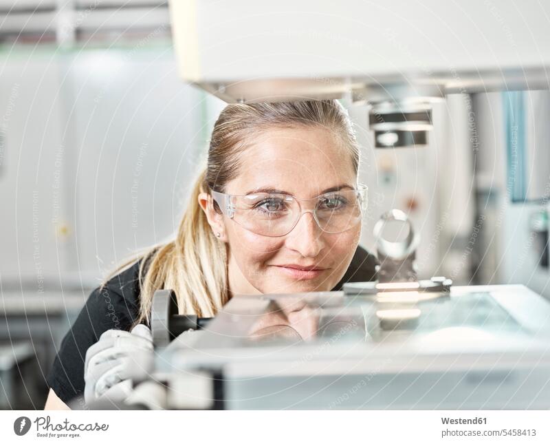 Woman working on a machine, looking on spring smiling smile accuracy accurate Precision Exactitude Exactness exact Quality springs Gritty Women Gritty Woman
