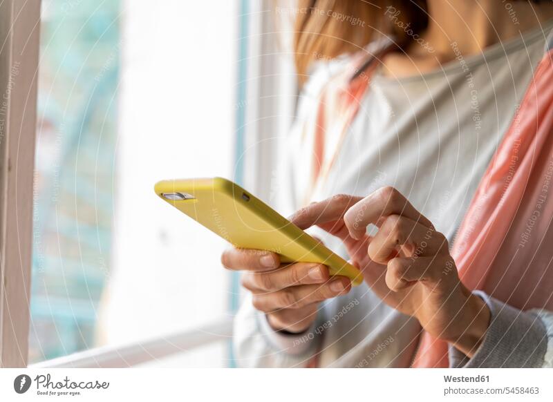 Close-up of woman using cell phone at the window business life business world business person businesspeople business woman business women businesswomen windows