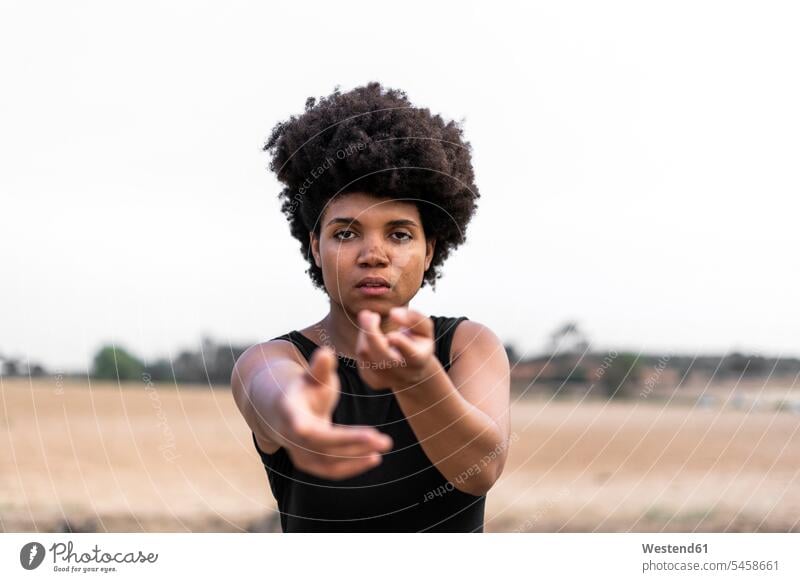 Portrait of young woman reaching out hands for help Helplessness colour colours country country side countryside Distinct individual look looks skies