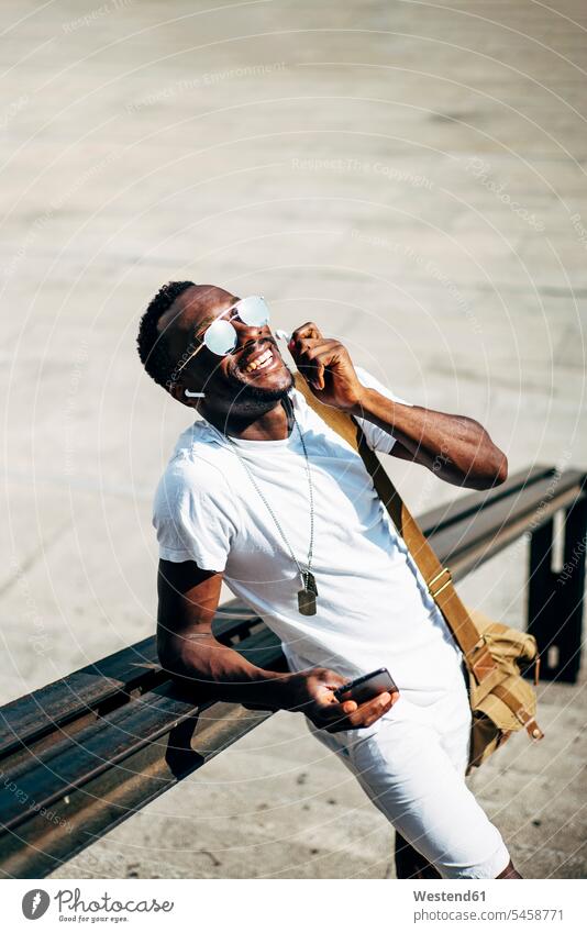 Happy young man with earphones and mobile phone in the city human human being human beings humans person persons African black black ethnicity coloured 1