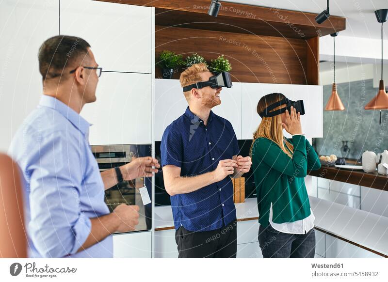 Couple wearing VR glasses shopping for a new kitchen in showroom human human being human beings humans person persons client clientele clients customers