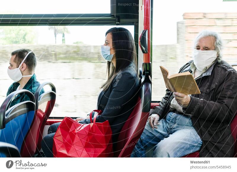 Passengers wearing protective masks in public bus, Spain books transport motor vehicles road vehicle road vehicles buses busses read travel traveling mobile