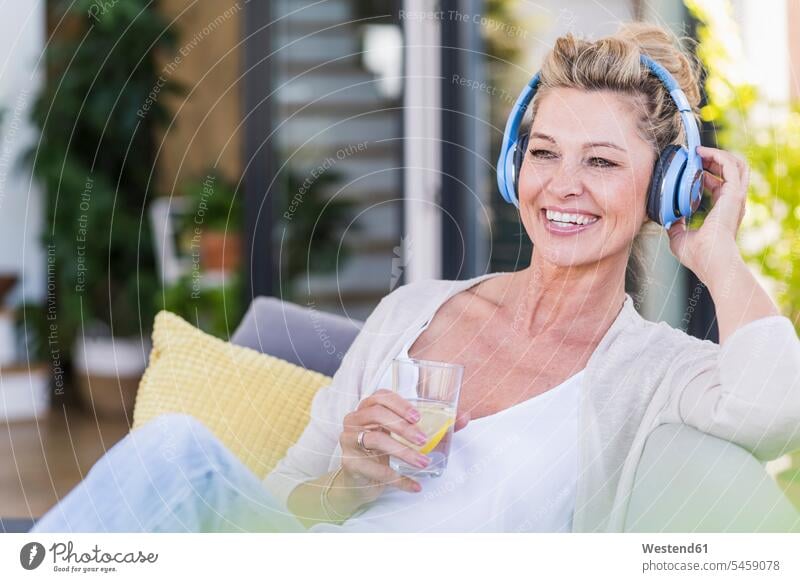senior woman with wireless earphones sitting in yoga pose on mat isolated  on grey,stock image Stock Photo - Alamy