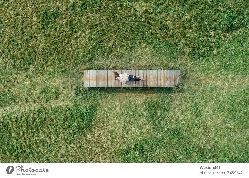 Top view of a young woman lying on boardwalk females women laying down lie lying down boardwalks wooden walkway Adults grown-ups grownups adult people persons