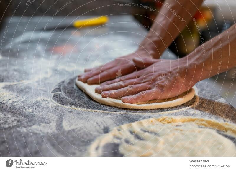 Close-up of pizza baker preparing pizza dough in kitchen Food Preparation preparing food Pizza Dough Pizzas preparation prepare foods food and drink Nutrition