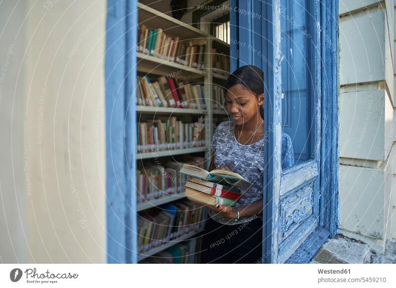Young woman checking books at National library, Maputo, Mocambique rack racks Shelve shelves book shelf Book Shelves bookshelves learn read smile study delight