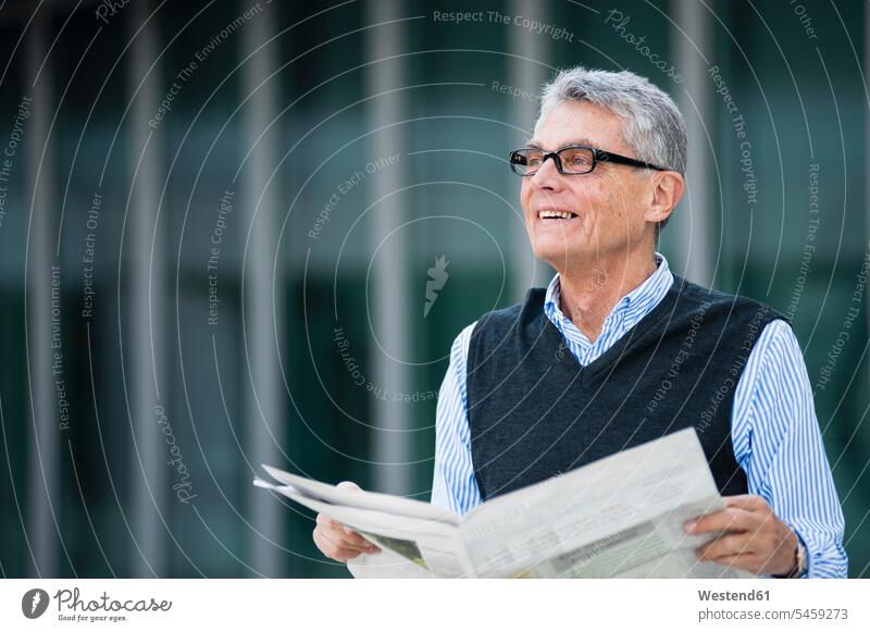 Portrait of smiling senior businessman with newspaper outdoors business life business world business person businesspeople Business man Business men Businessmen