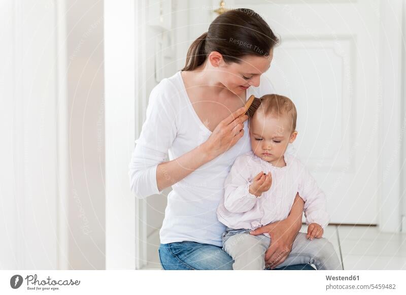 Mother brushing baby's hair at home infants nurselings babies mother mommy mothers ma mummy mama people persons human being humans human beings parents family