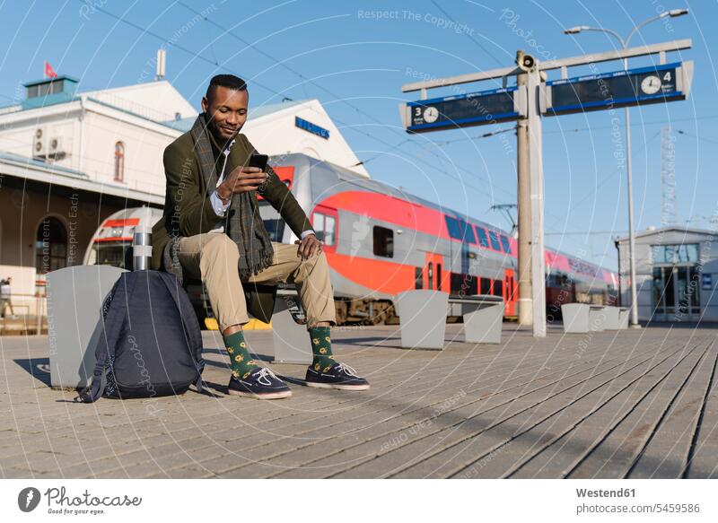 Stylish man using smartphone while waiting for the train business life business world business person businesspeople Business man Business men Businessmen human