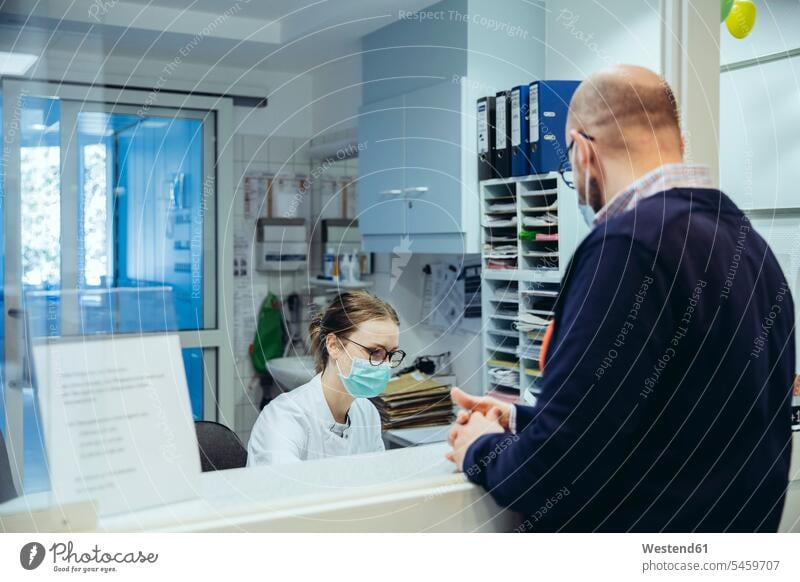 Employee at reception desk of hospital ward and visitor health healthcare Healthcare And Medicines medical medicine disease diseases ill illnesses sick Sickness