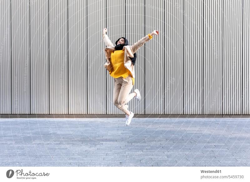 Portrait of happy young woman jumping in the air human human being human beings humans person persons Middle Eastern 1 one person only only one person adult