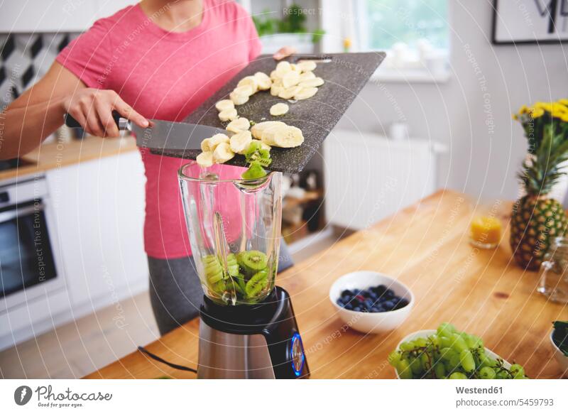 Young woman preparing smoothie in the kitchen, partial view Smoothies females women domestic kitchen kitchens Food Preparation preparing food Drink beverages