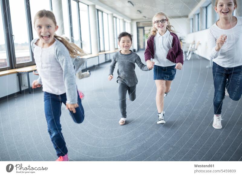 Excited schoolgirls rushing down school corridor female pupils School Girl School Girls happiness happy schools hallway corridors hallways running