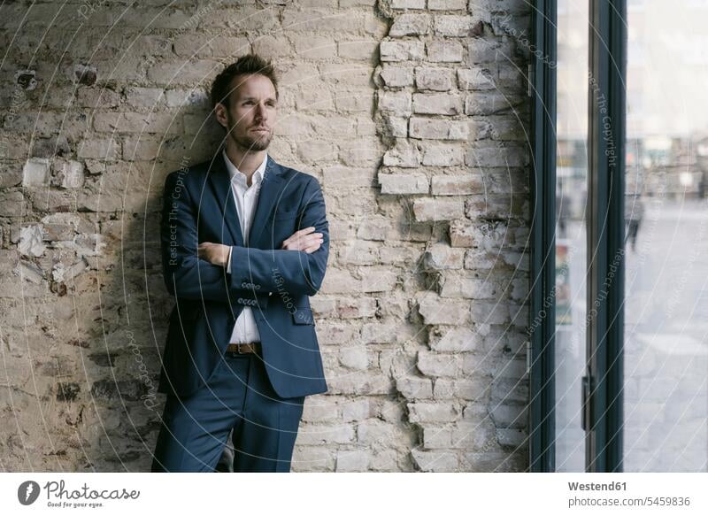 Portrait of businessman leaning against brick wall Occupation Work job jobs profession professional occupation business life business world business person