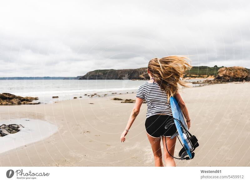 Young woman with surfboard running on the beach surfboards carrying surfer female surfer surfers female surfers young women young woman beaches surfing